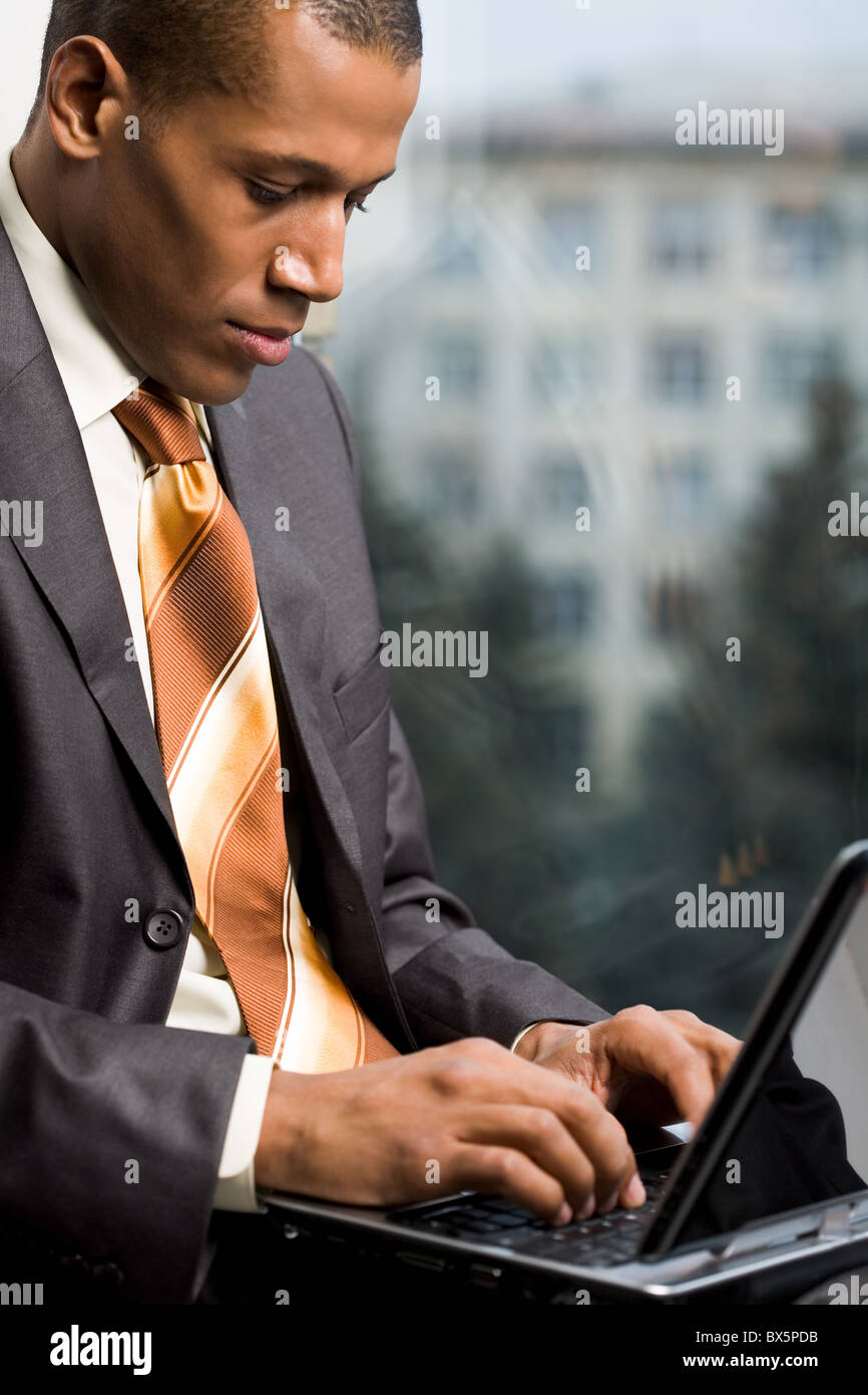 Photo of handsome employee working in office with laptop in front Stock Photo