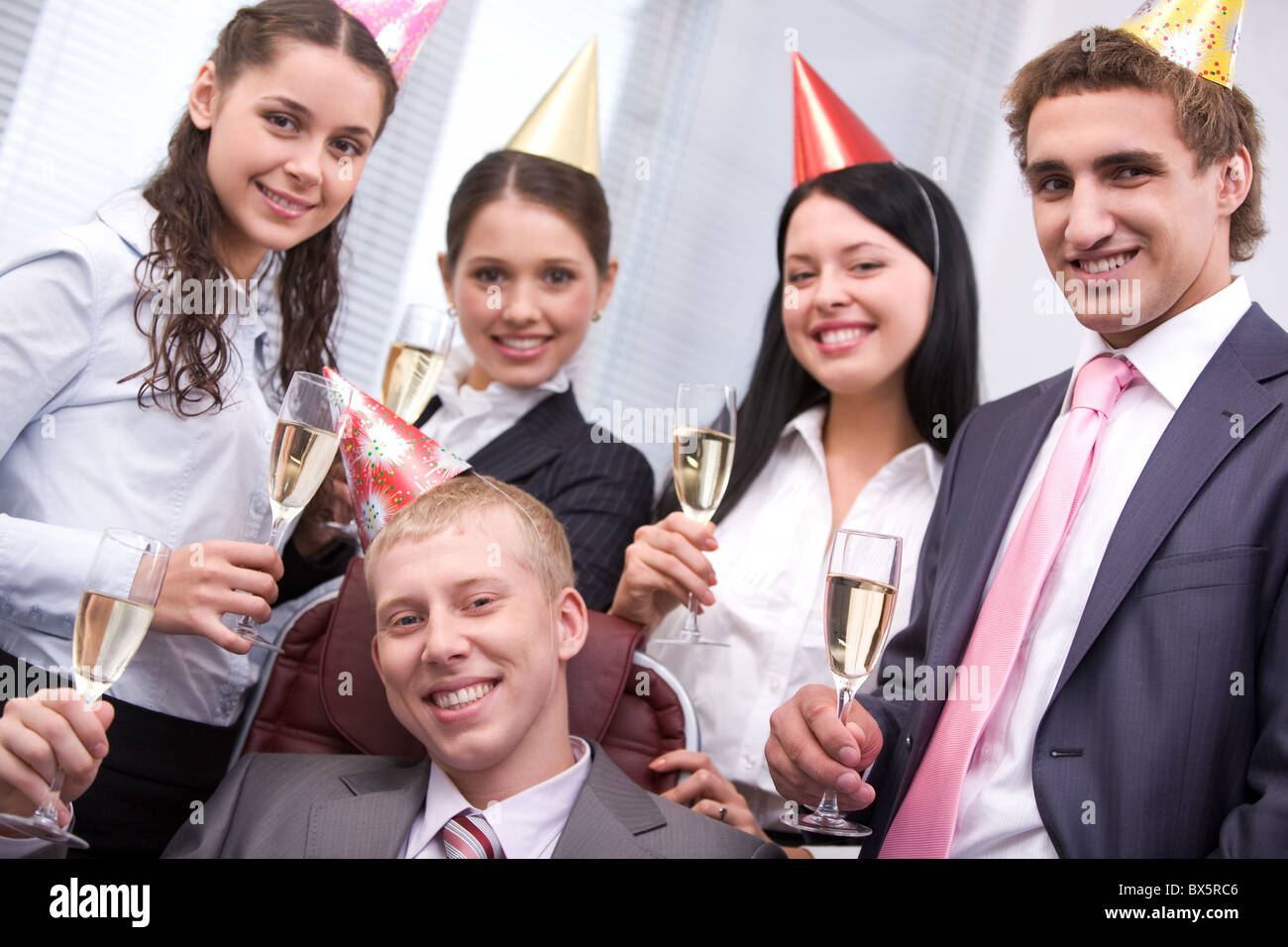 Portrait of joyful male wearing birthday cap looking at camera on ...