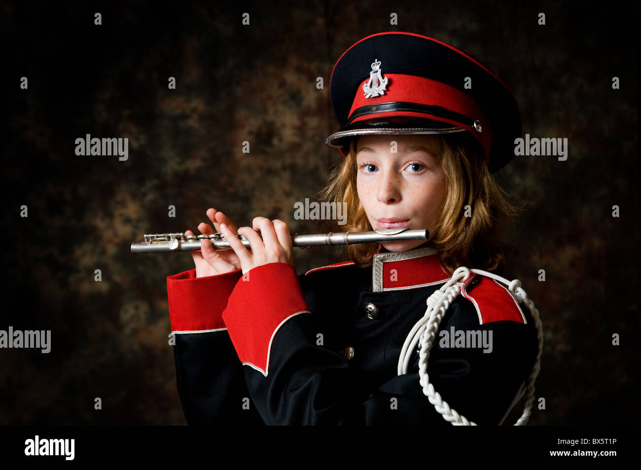 girl in a band uniform playing a flute Stock Photo