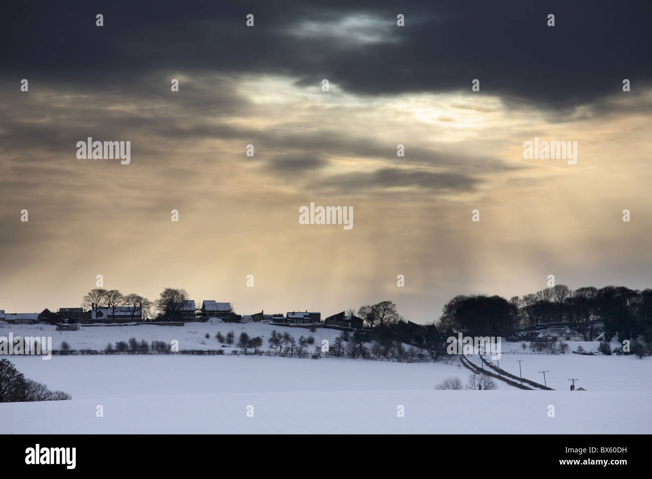 Light breaking through clouds above a snow covered landscape. Offerton, near Sunderland, Tyne and Wear, England, UK Stock Photo