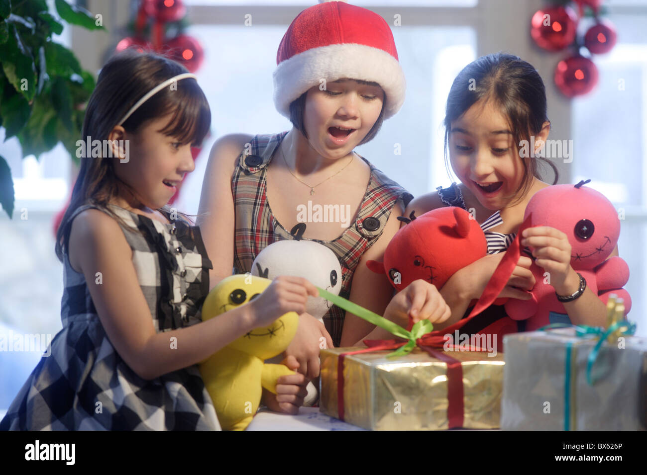 Three girls  opening Christmas presents Stock Photo