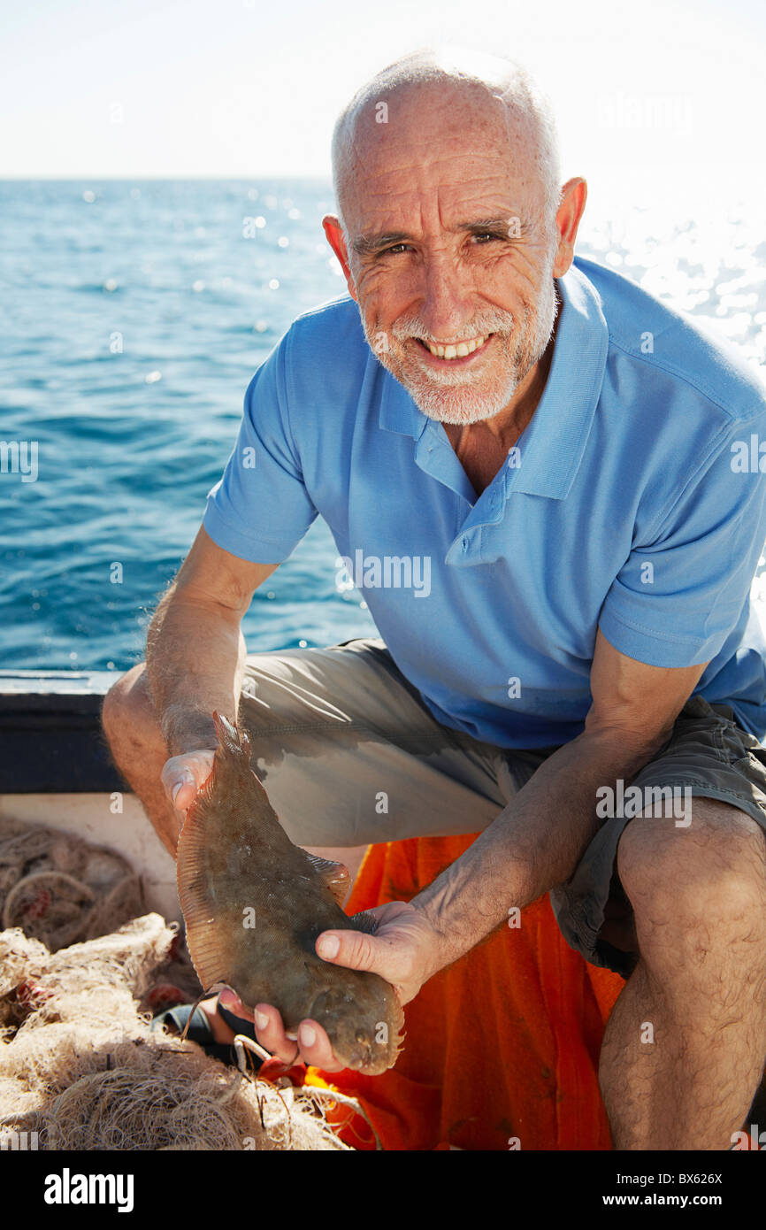 Fisherman holding fish Stock Photo