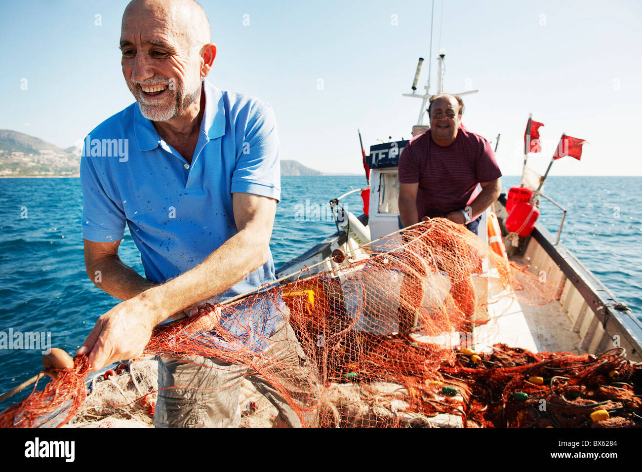 Fisherman pulling in nets Stock Photo