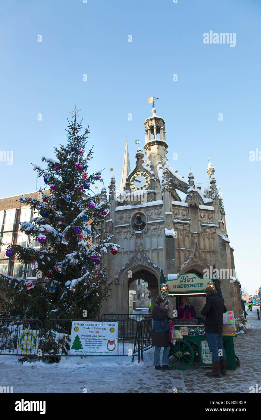 England, West Sussex, Chichester, the Cross and Christmas tree in snow with roast chestnut 