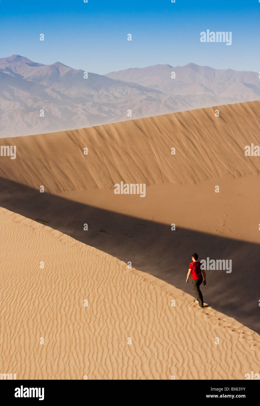 Man walking up a sanddune in Death Valley National Park. Stock Photo