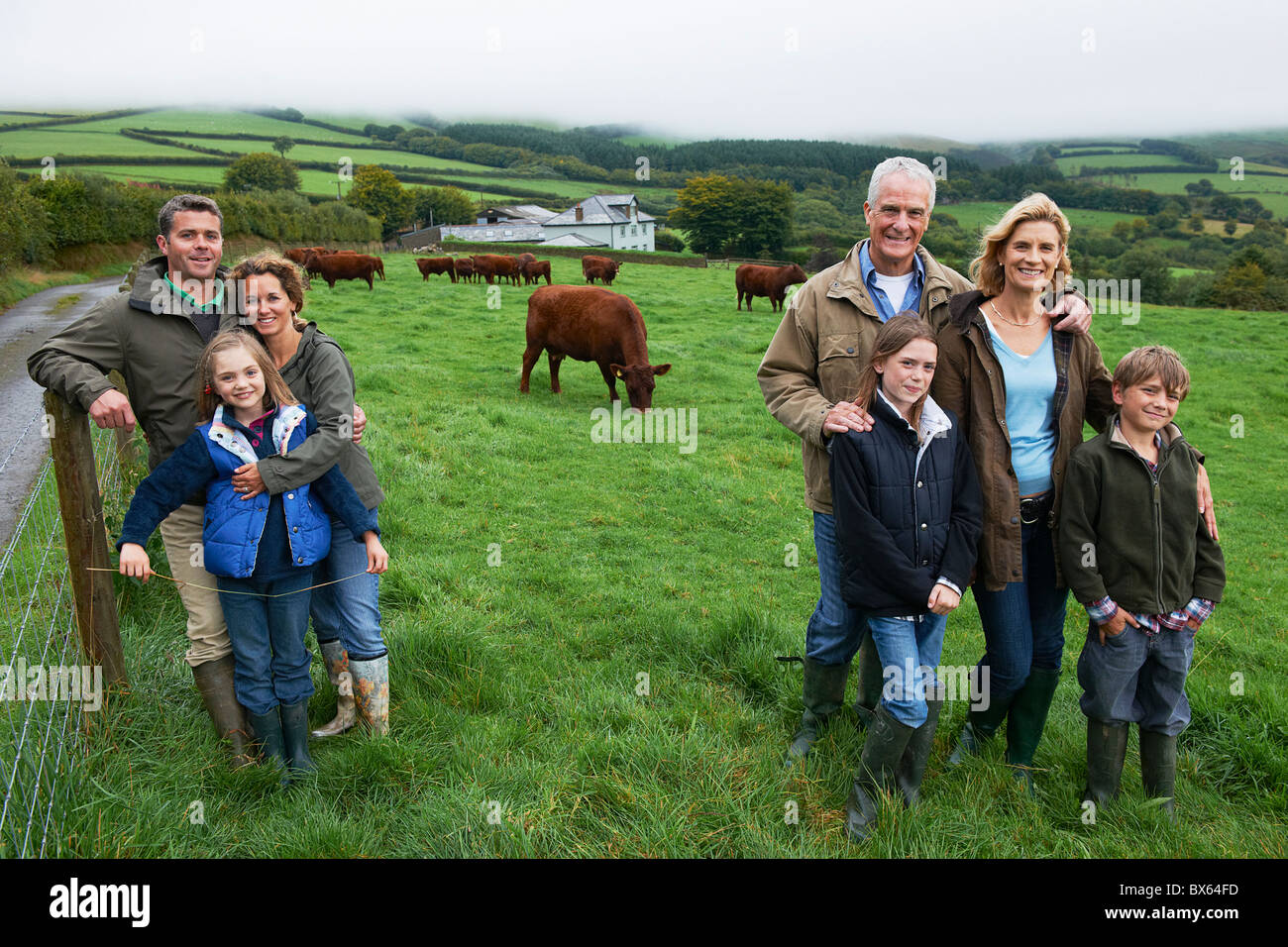 Family on farm in a field with cows Stock Photo