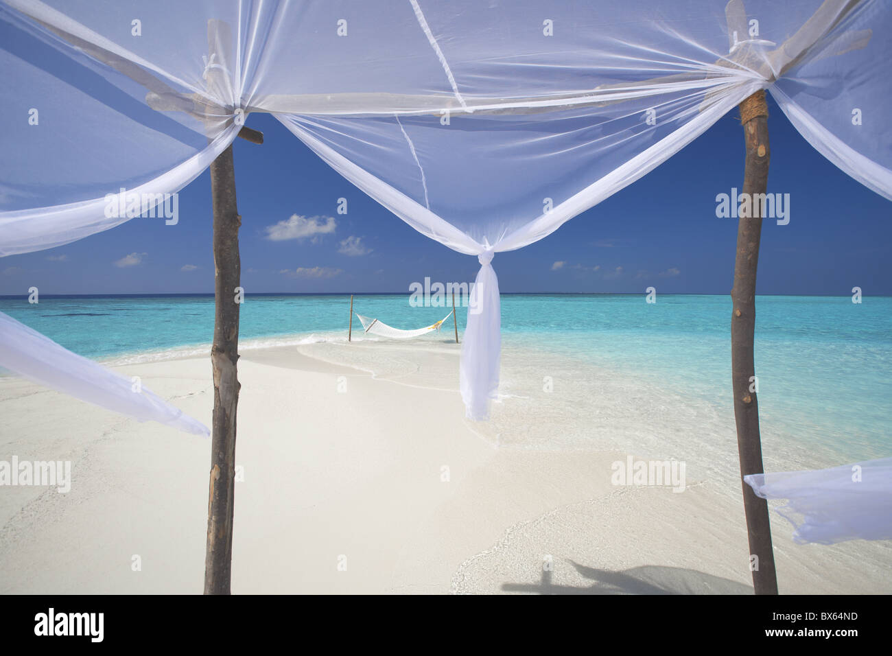 Hammock hanging in shallow clear water, The Maldives, Indian Ocean, Asia Stock Photo