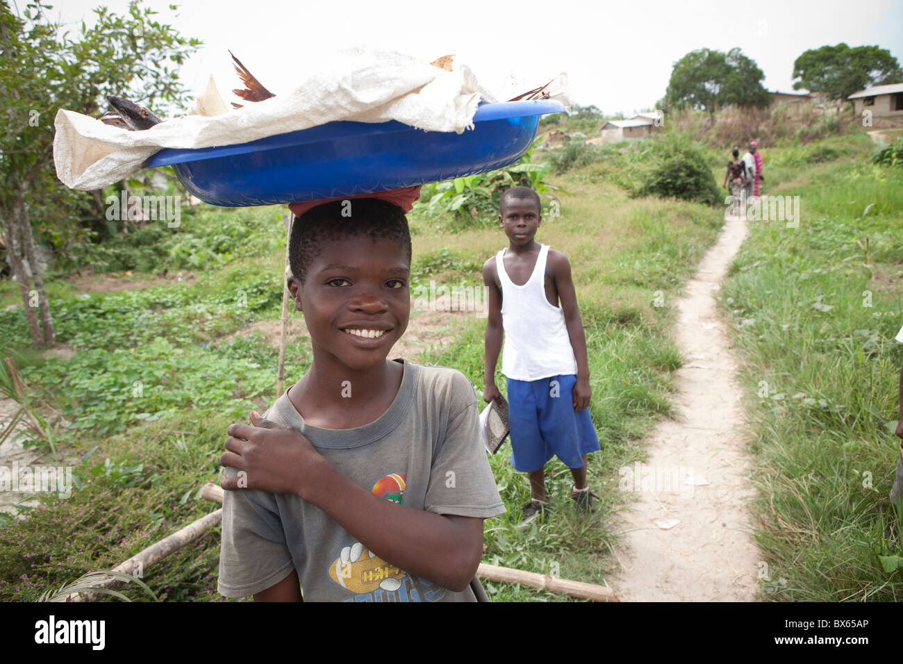 Villagers walk along a path in Kakata, Liberia, West Africa Stock Photo