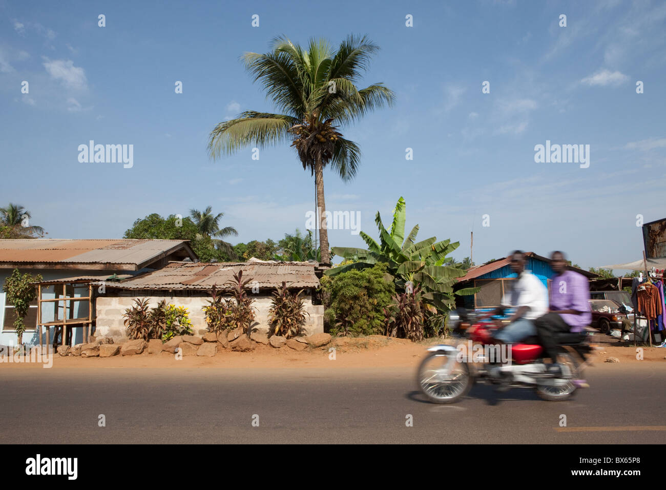 A motorcycle zooms down the road in Monrovia, Liberia, West Africa. Stock Photo