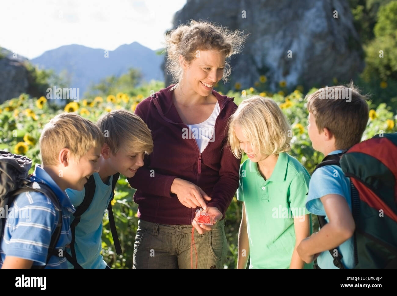 Woman explaining a compass to boys Stock Photo - Alamy