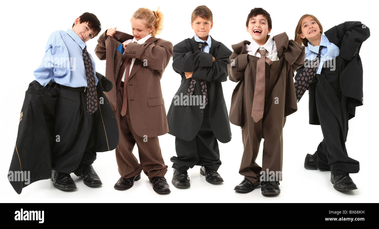 Adorable 7 year old children, boys and girls, in brown and blue baggy men's suits and big shoes over white background. Stock Photo