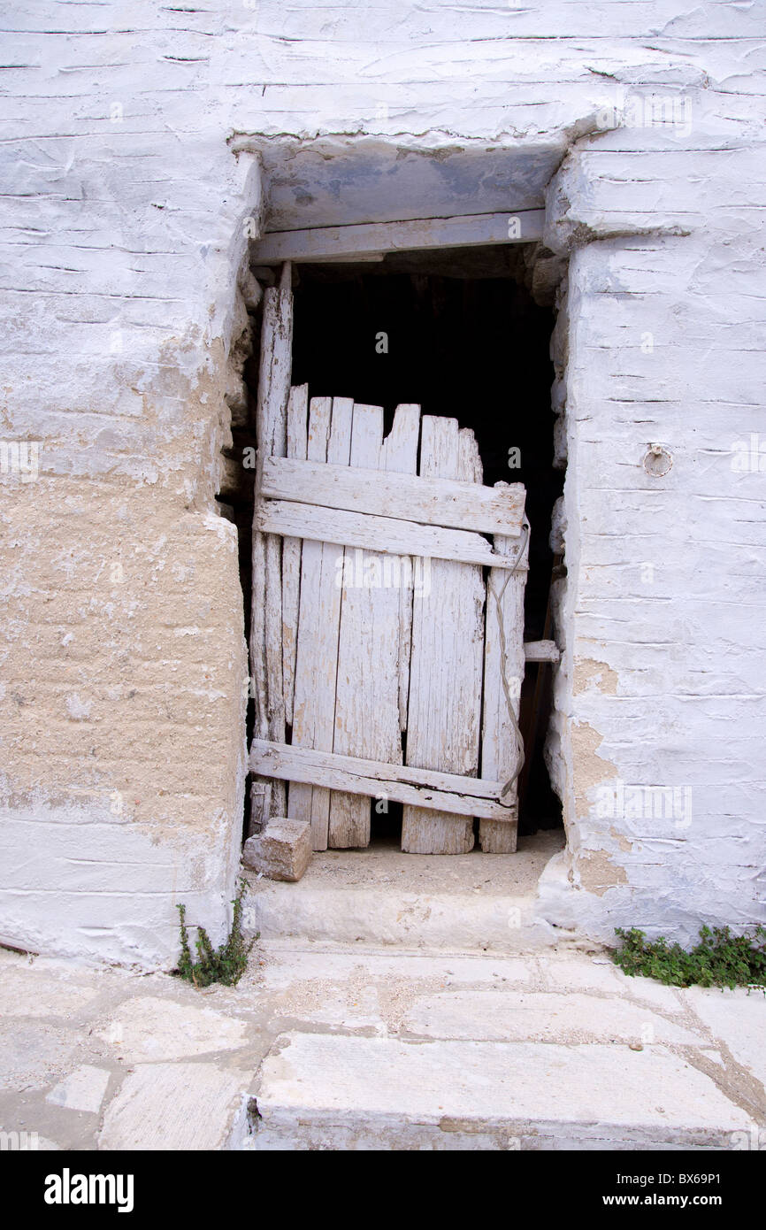 Rickety wooden door of an old whitewashed house in Arnados, on the Greek Cyclade island of Tinos. Stock Photo