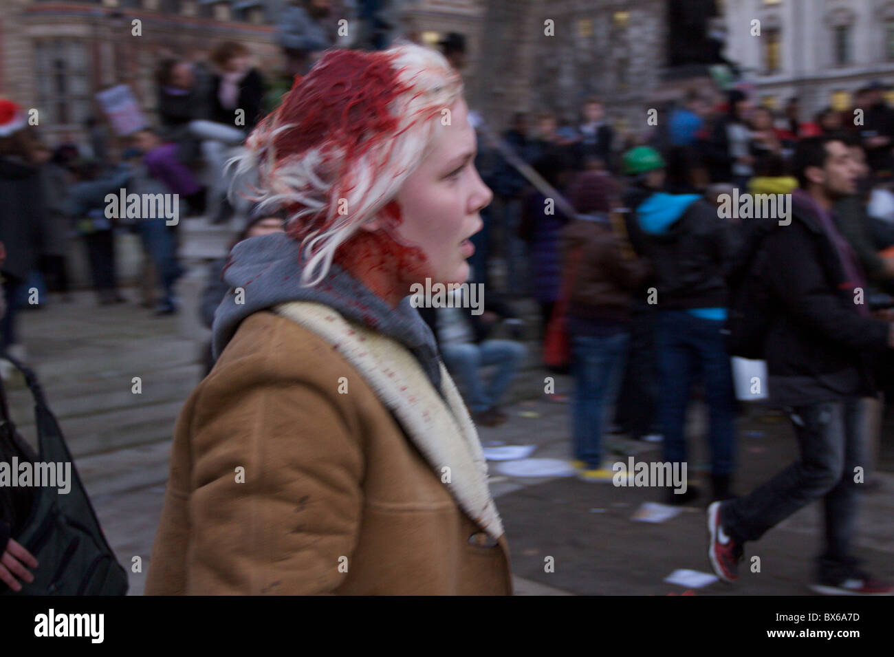A young girls head bleeds during violent student protests against rise to tuition fees in Parliament Square, central London. Stock Photo