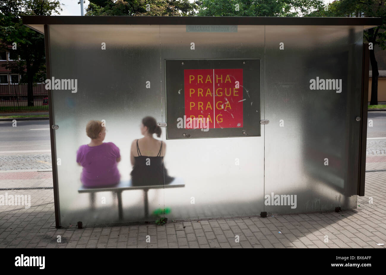 Two women sit at a bus stop in Prague, Czeh Republic.  (CTK Photo/Rene Fluger) Stock Photo