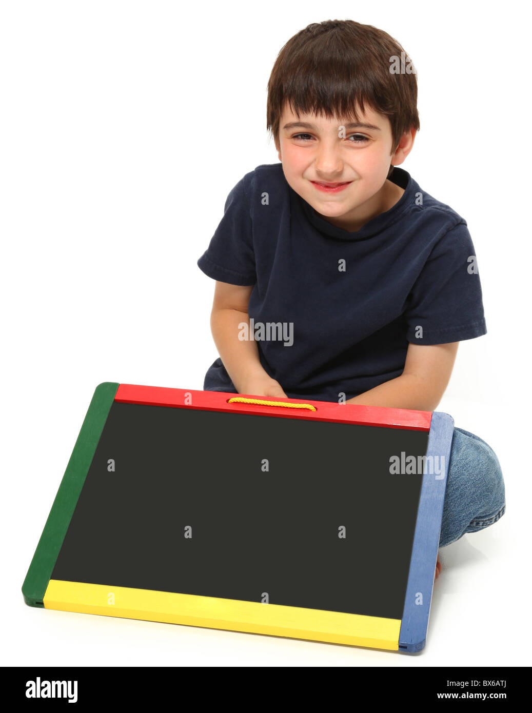 adorable seven year old boy holding blank chalkboard Stock Photo
