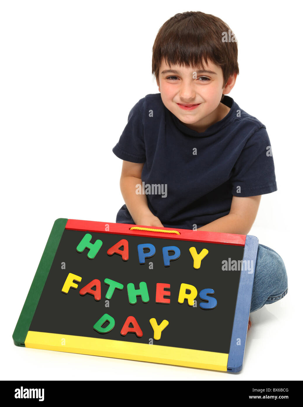 adorable seven year old boy holding happy fathers day magnetic chalkboard Stock Photo