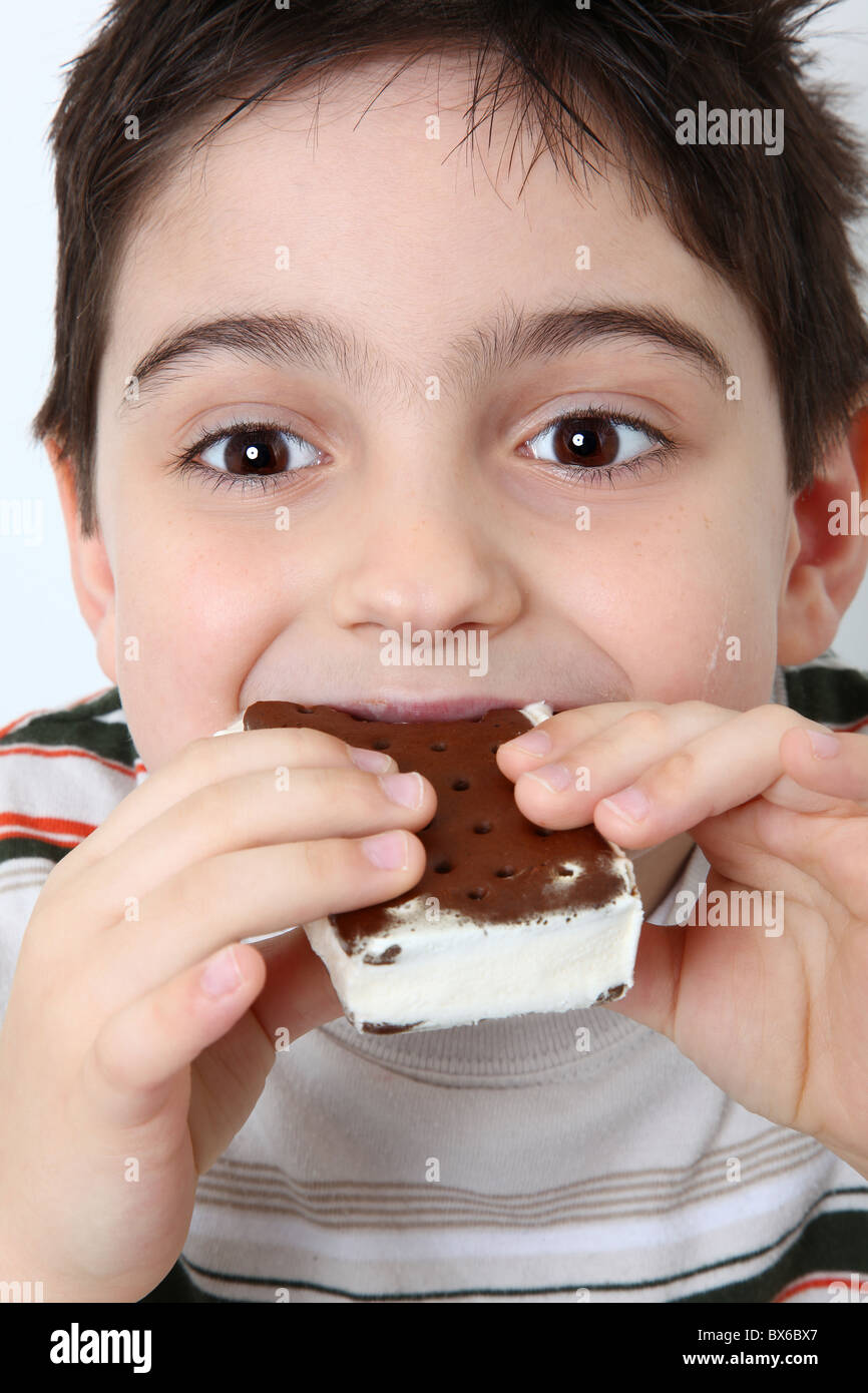 Adorable six year old boy eating icecream sandwich Stock Photo Alamy
