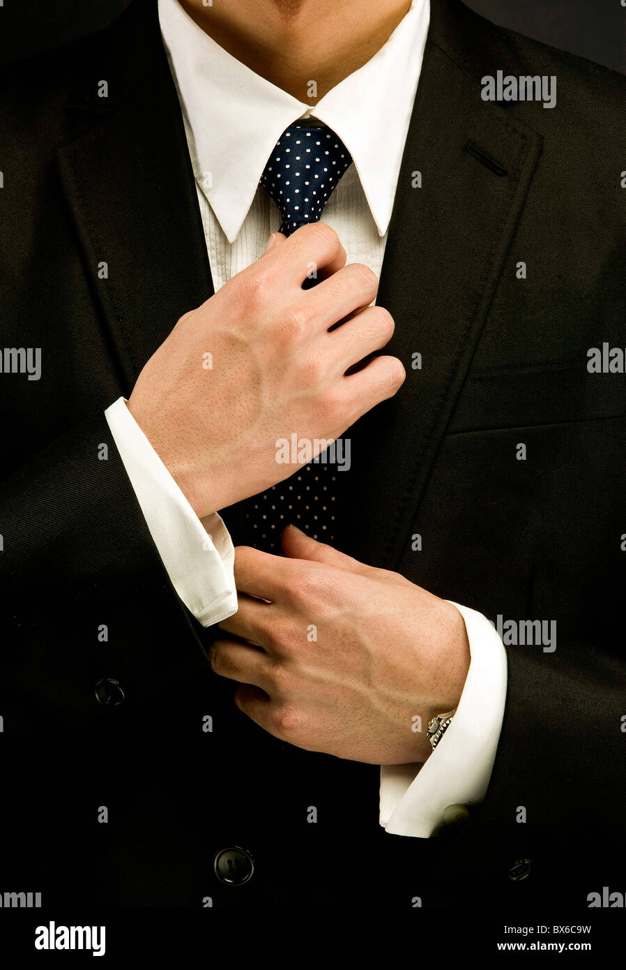 A businessman adjusting tie Stock Photo - Alamy