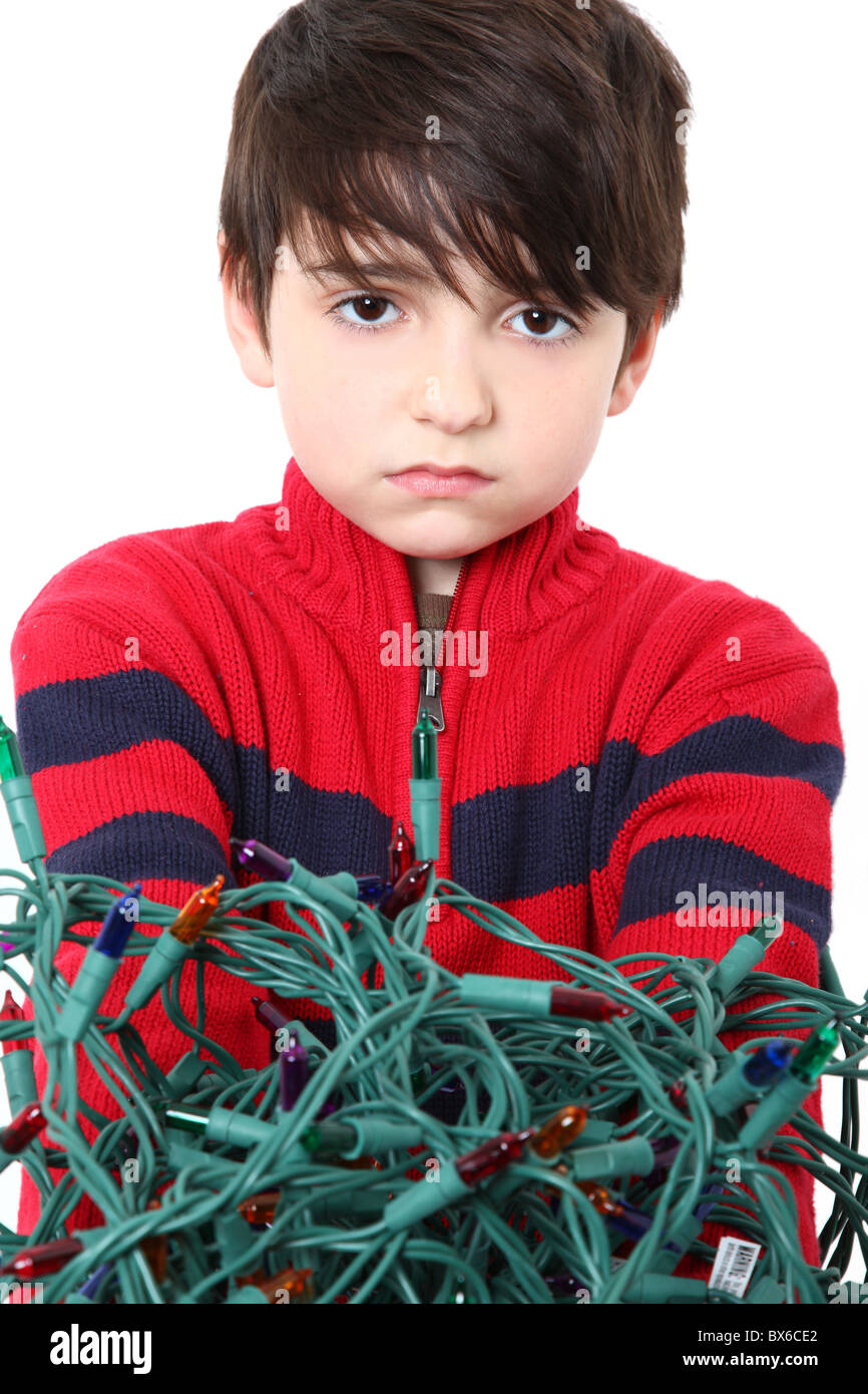 Six year old boy with tangled Christmas tree lights Stock Photo Alamy