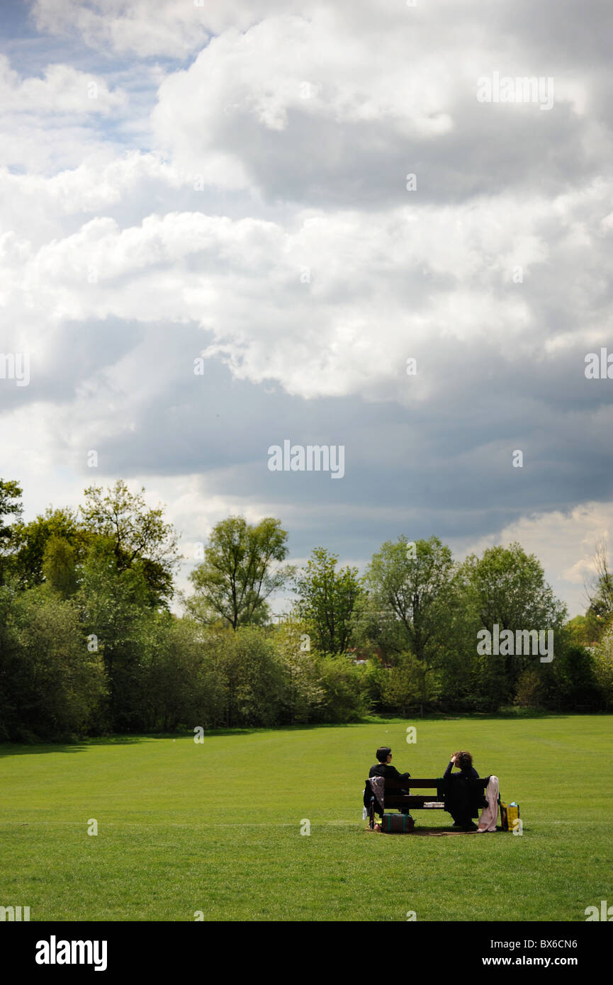 Two Woman Chatting On A Bench in Highgate Woods, North London Stock Photo