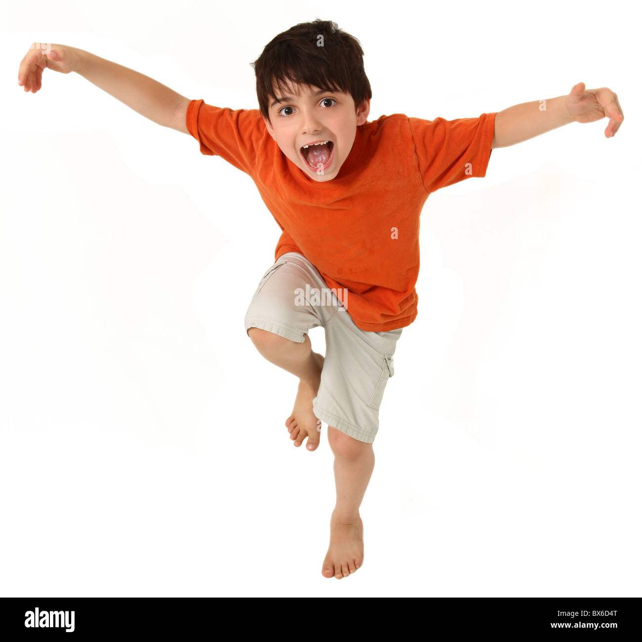 Adorable seven year old boy pretending to do kung fu or being a bird. Stock Photo