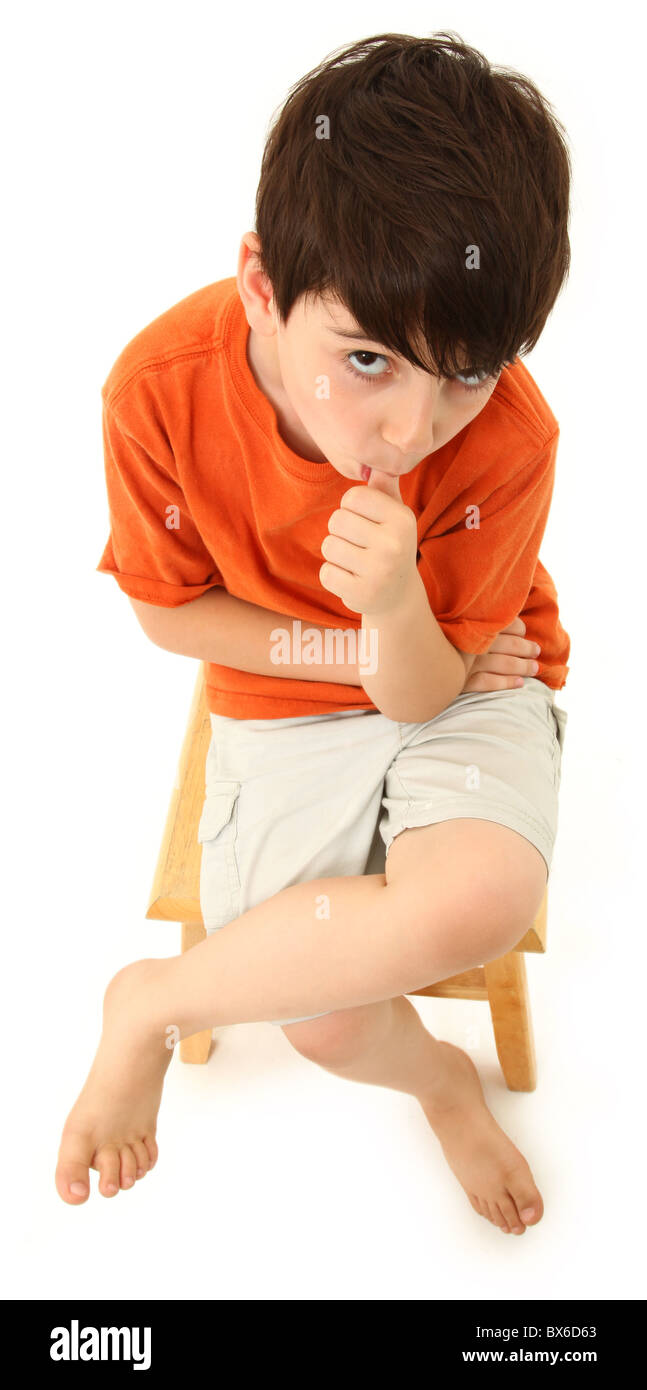 Handsome seven year old boy sucking thumb over white background. Stock Photo
