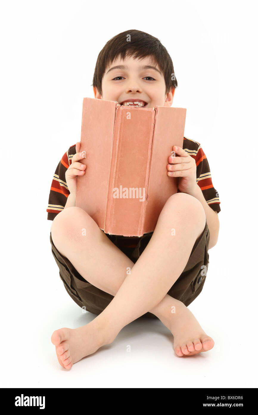 Casual happy seven year old french american boy with large book over white background. Stock Photo