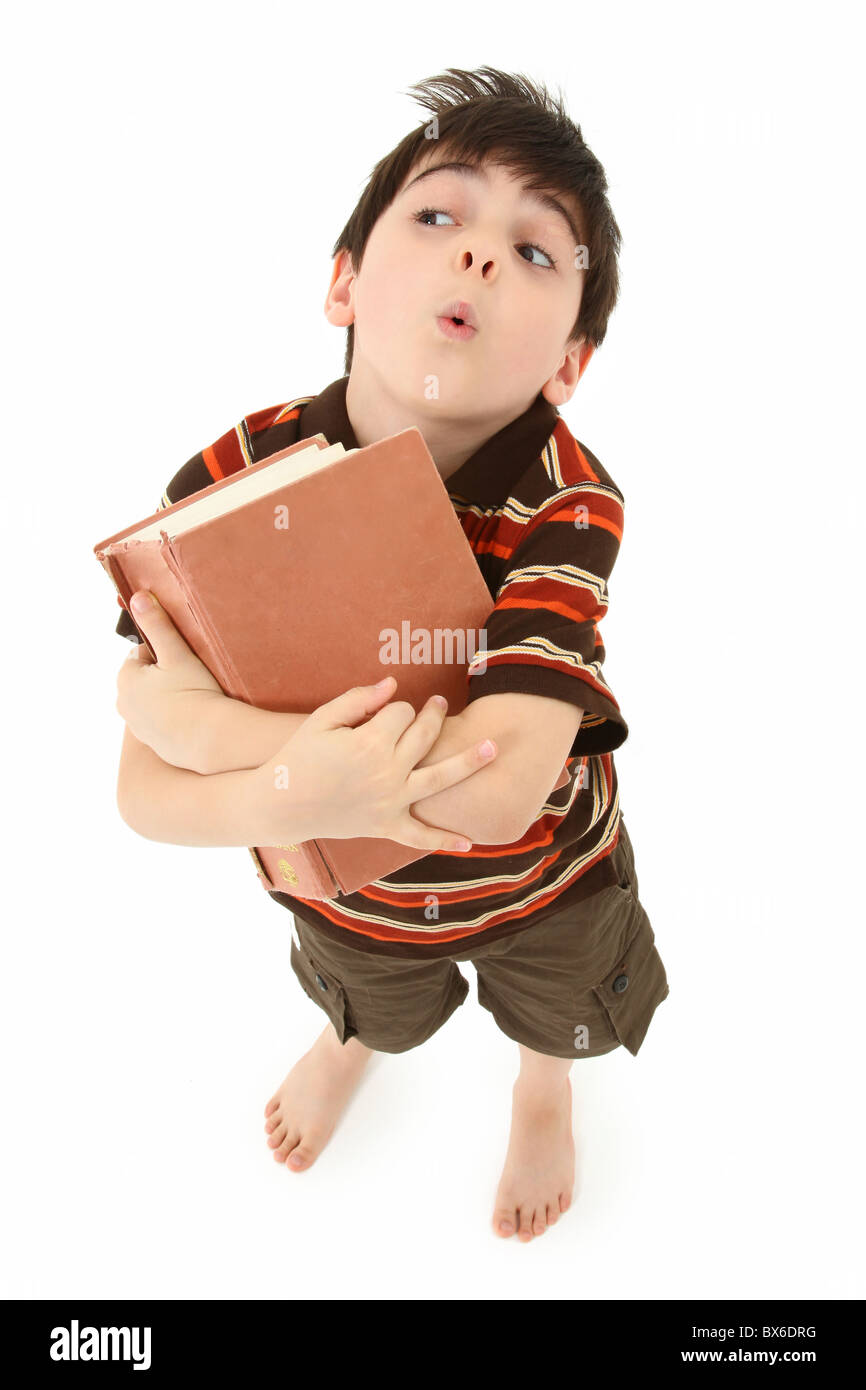 Adorable seven year old french american boy standing with large book over white background. Stock Photo