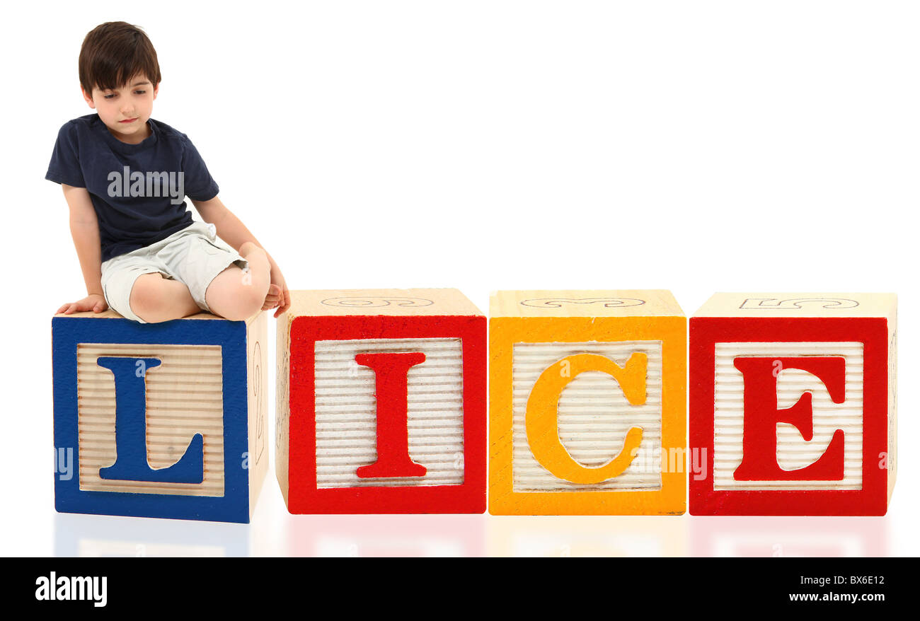 Attractive seven year old french american boy sitting on giant word lice. Stock Photo
