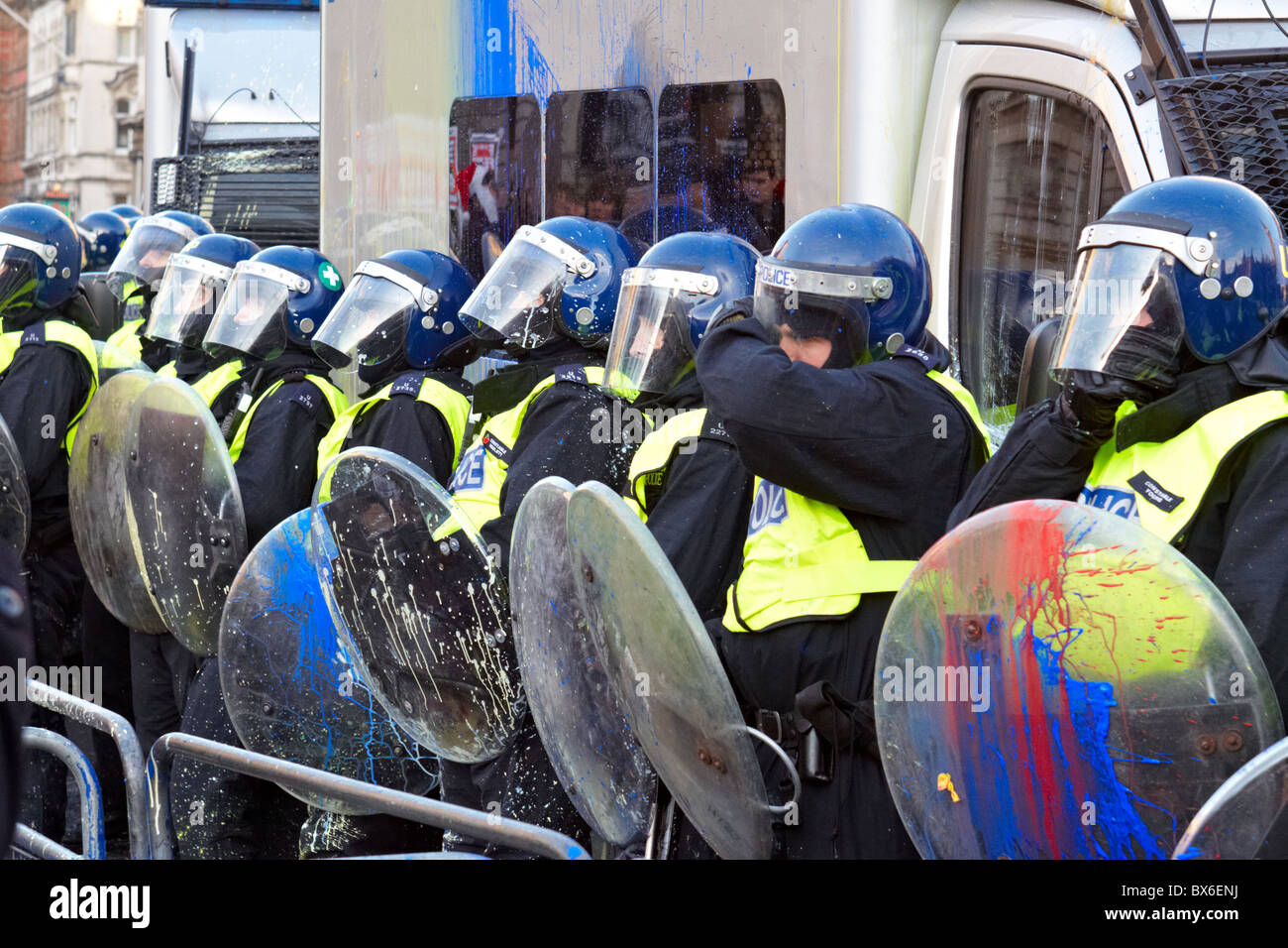 LONDON, UK. Police with riot shields are splattered with paint bombs during the fourth round of student protests Stock Photo