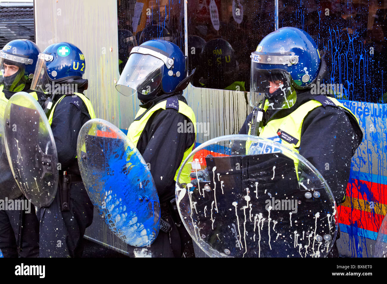 LONDON, UK. Police with riot shields are splattered with paint bombs during the fourth round of student protests Stock Photo