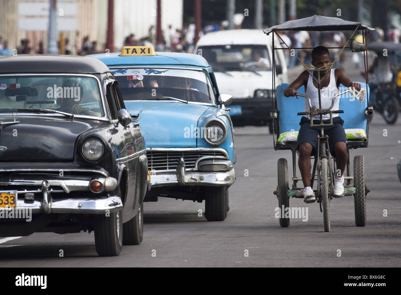 Vintage American cars and a bici (bicycle taxi) in Havana, Cuba, West Indies, Central America Stock Photo