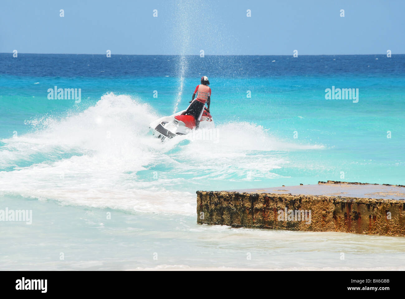 Jet ski on ocean waters. A jet skier races out from shore Stock Photo