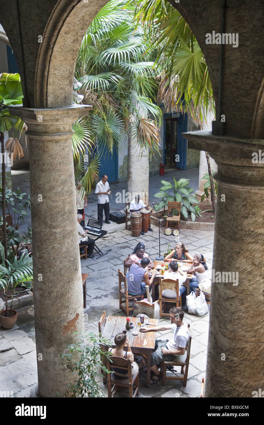 People sitting at tables and musicians playing in courtyard of colonial building built in 1780, Havana, Cuba, West Indies Stock Photo