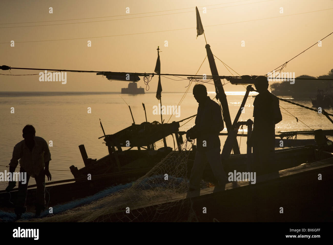 Fishermen, silhouetted in the golden light of dawn at Diu, Union Territory of Diu and Daman, India, Asia Stock Photo