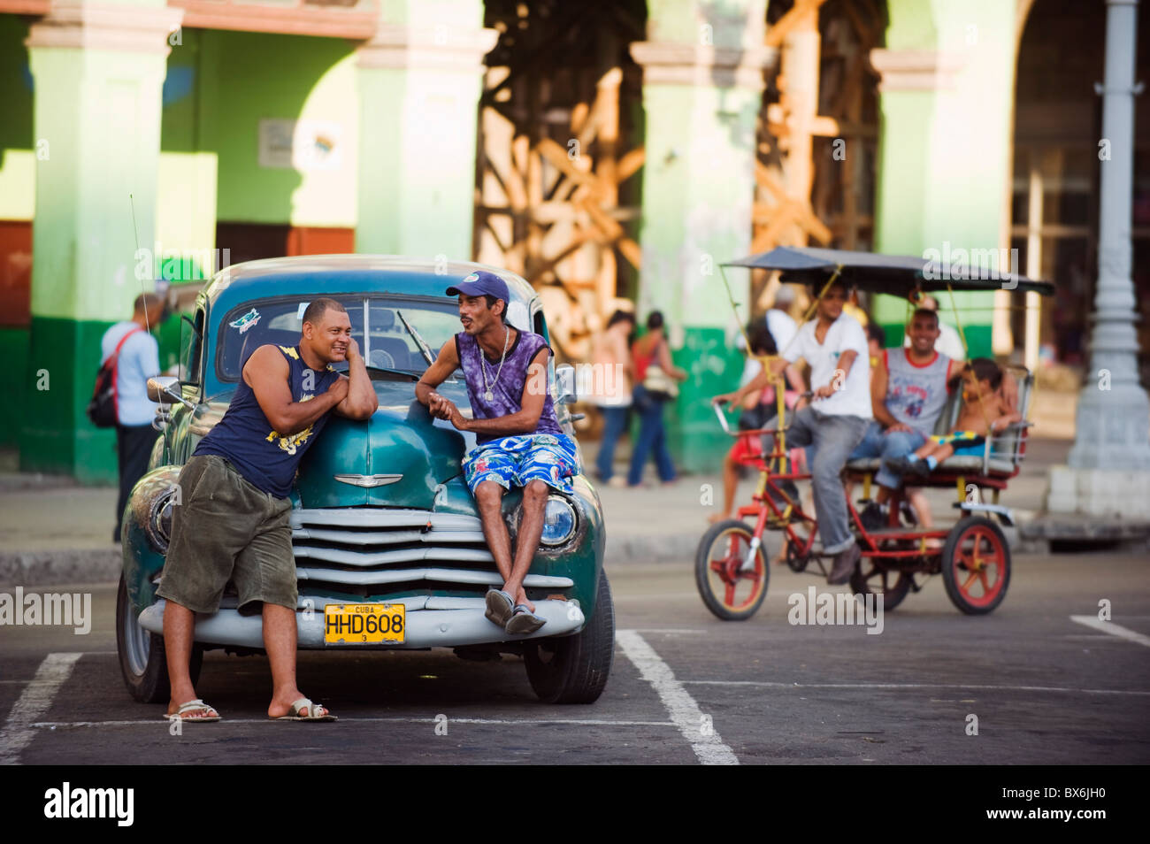 Men relaxing on a 1950s classic American car, Central Havana, Cuba, West Indies, Caribbean, Central America Stock Photo