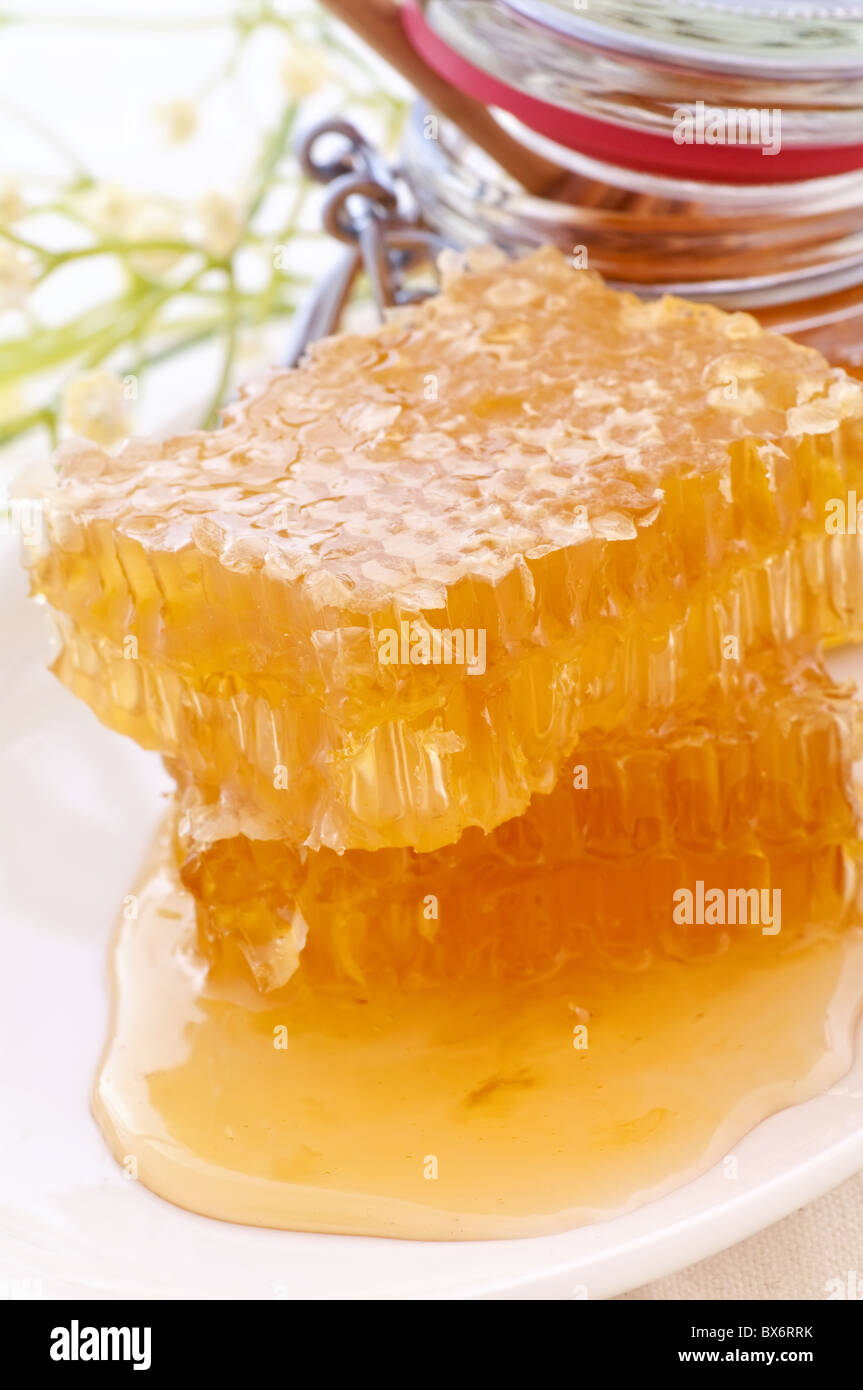 Piece of a with dripping honey as closeup Stock Photo Alamy