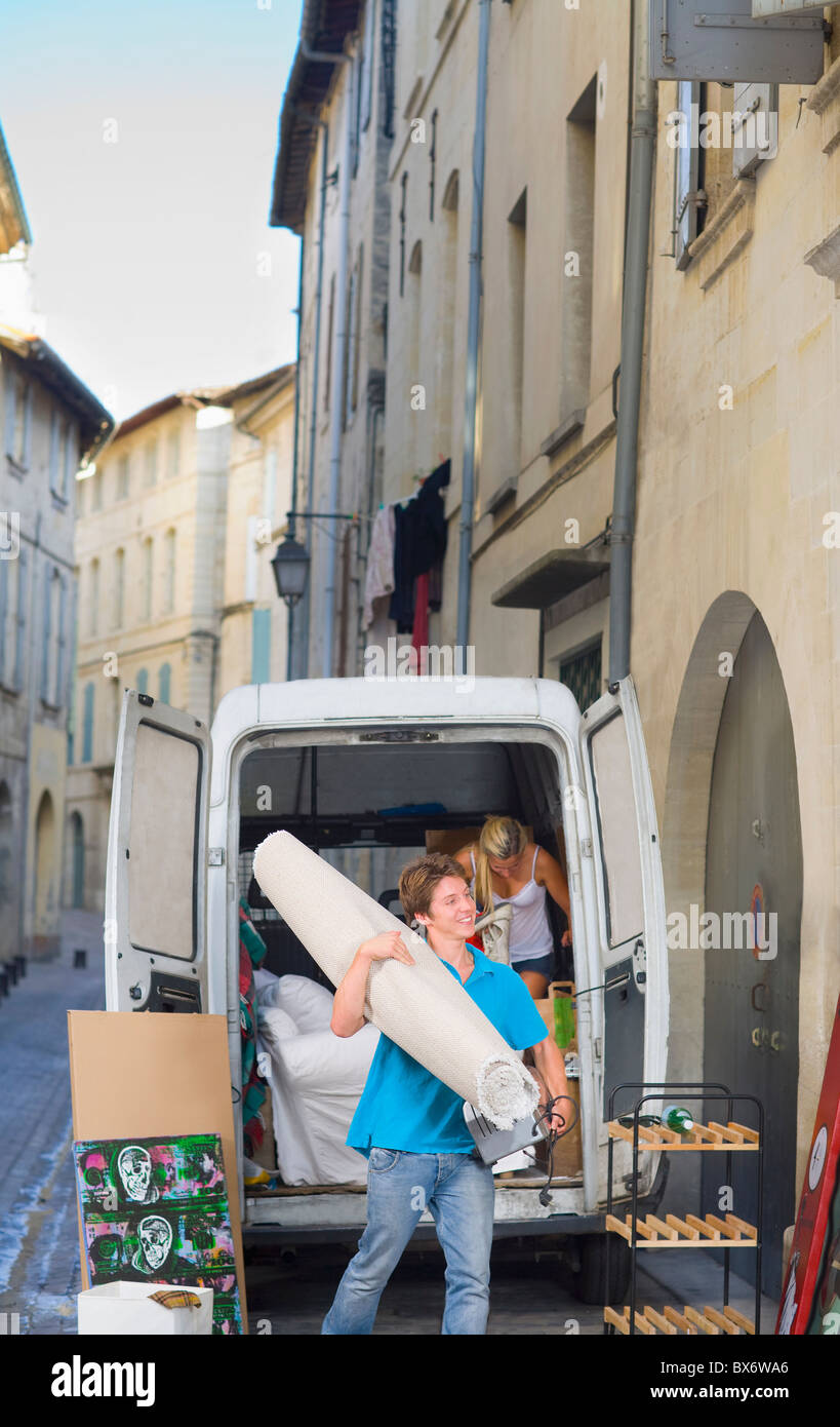 Couple with moving truck carrying rug Stock Photo - Alamy