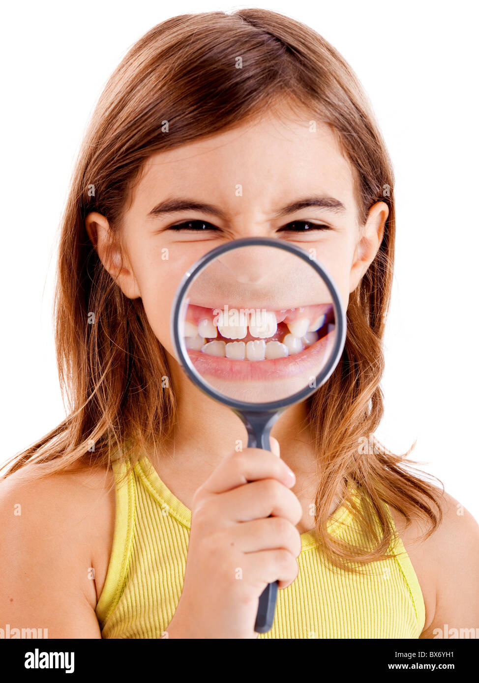 Beautiful girl showing teethes through a magnifying glass Stock Photo