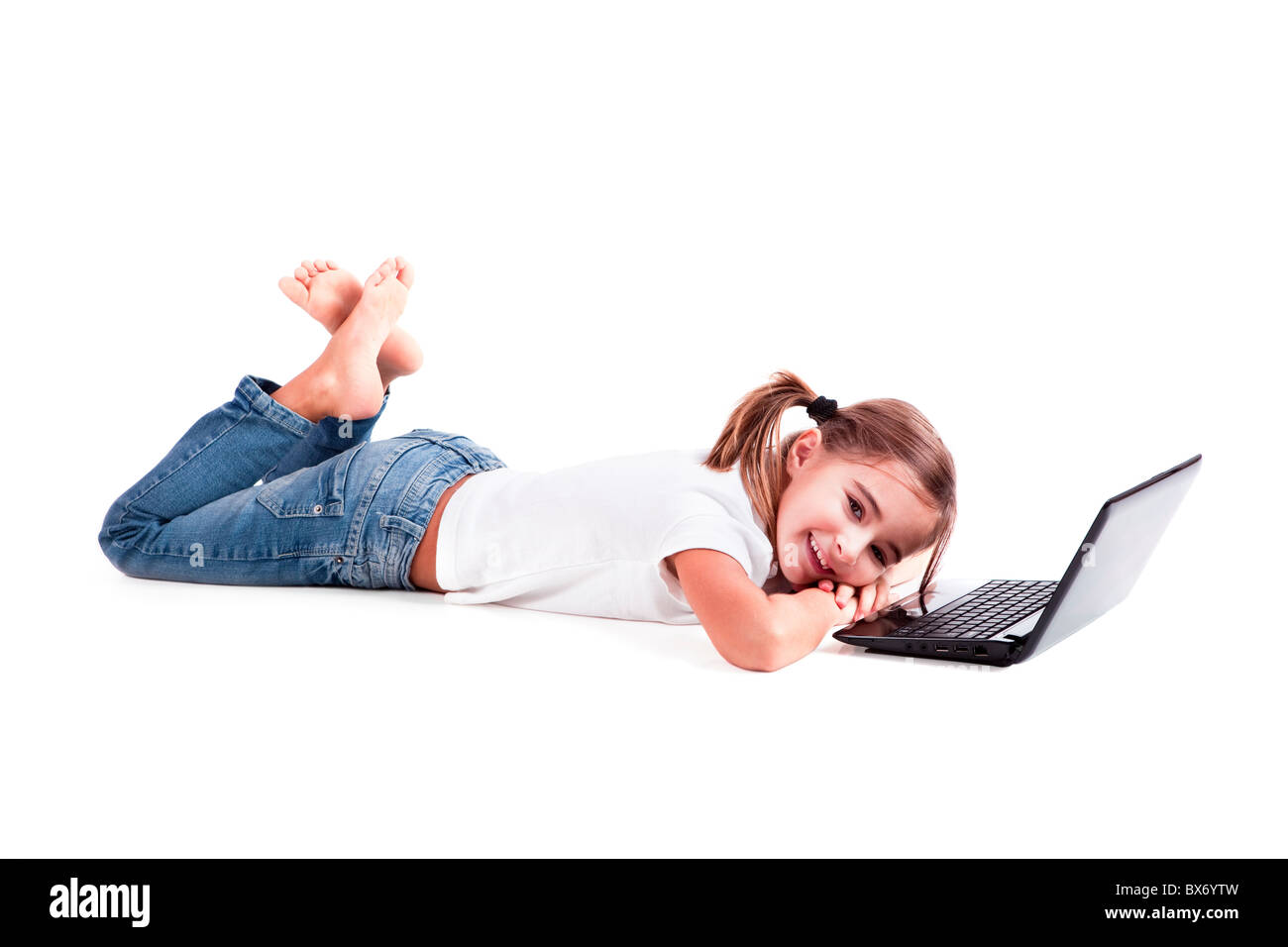 Little girl lying on floor working with a laptop Stock Photo - Alamy