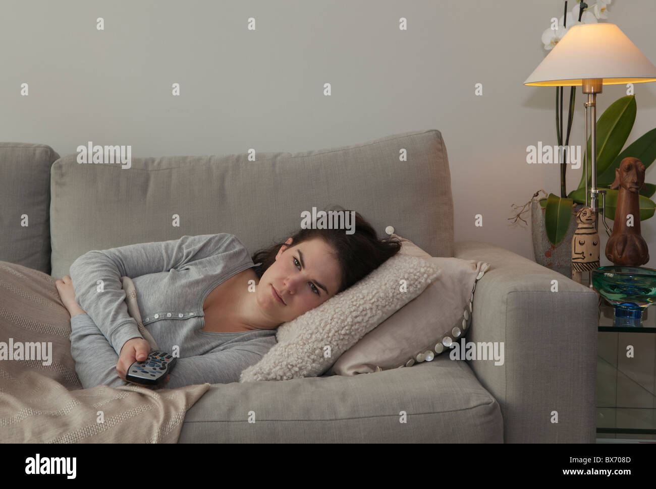 Young woman holding TV remote Stock Photo