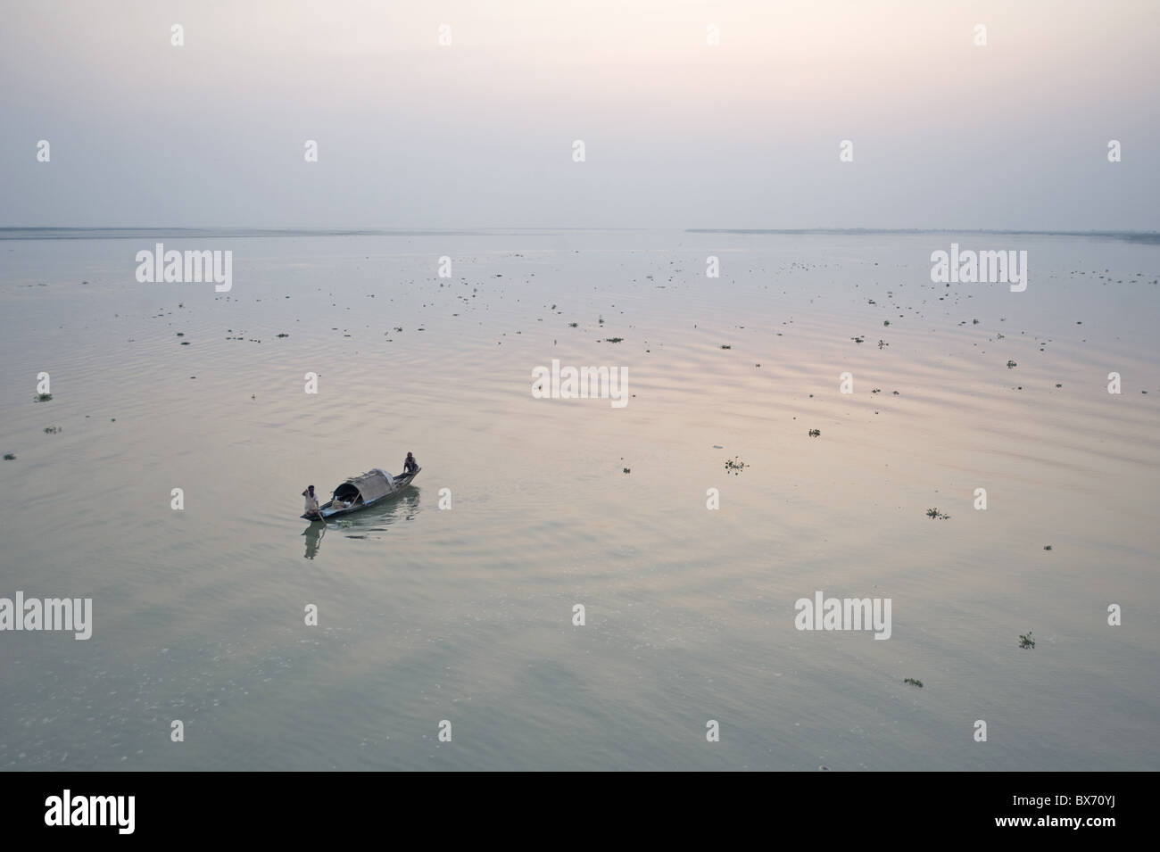 Two fisherman on boat at dawn on the Brahmaputra River, Assam, India, Asia Stock Photo