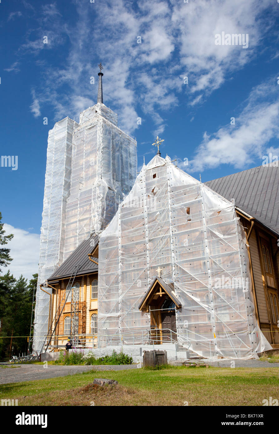 Plastic sheets covering the facade of an old wooden Lutheran church at