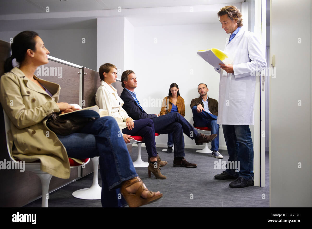 Doctor calling a patient in waiting room Stock Photo