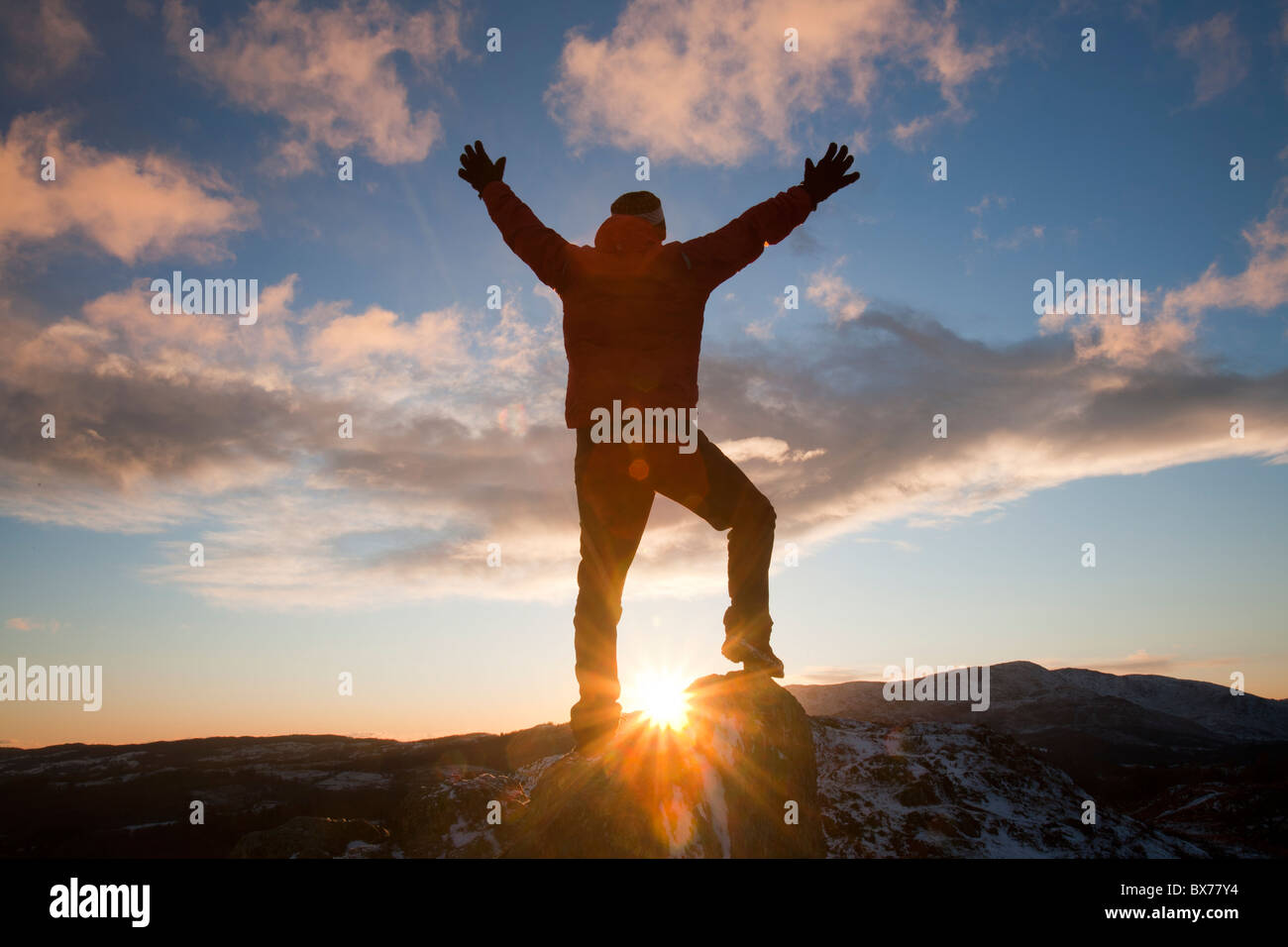 A mountaineer on Todd Crag summit in the Lake District, UK, at dusk. Stock Photo