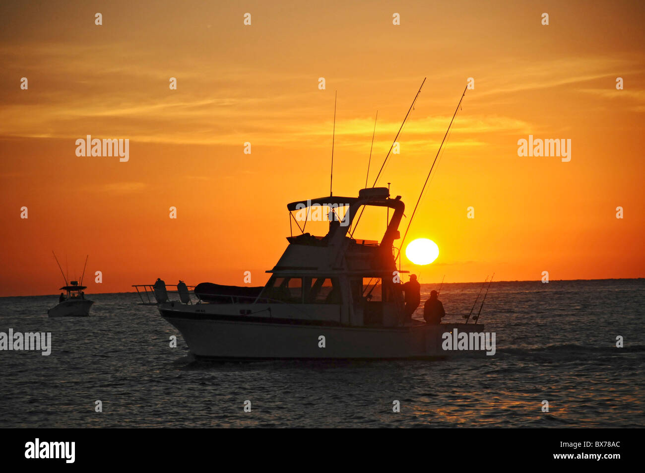 Chartered fishing boats off San Jose del Cabo, Mexico coast heading out into Pacific Ocean at dawn Stock Photo
