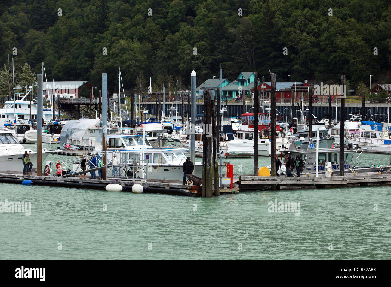 Fishing boats in the marina or harbor on the sea with forest in background at Skagway, Alaska, USA Stock Photo