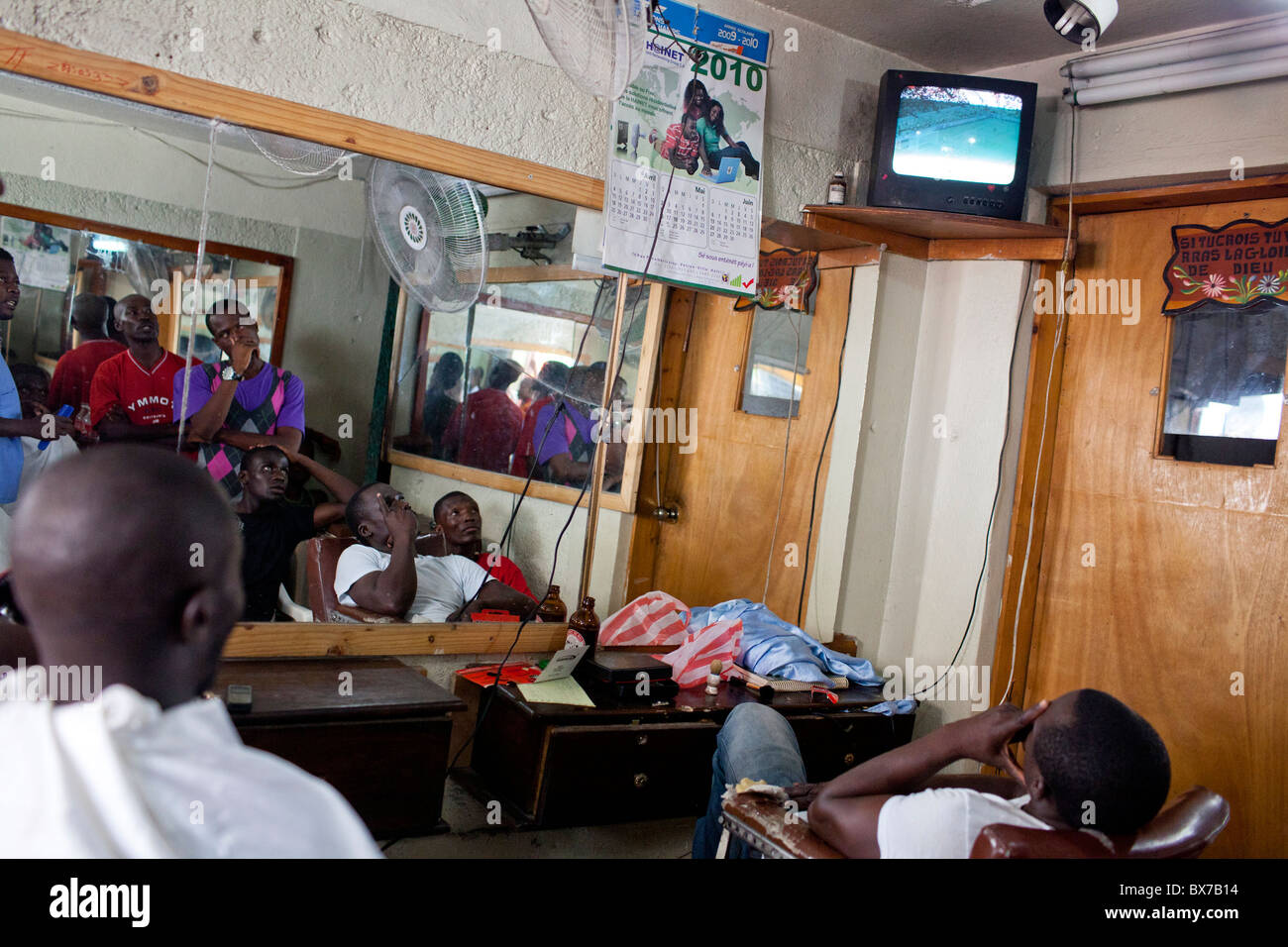 Men in a barber shop watch Spain play the Netherlands in the World Cup final on July 11, 2010 in Port-au-Prince, Haiti. Stock Photo