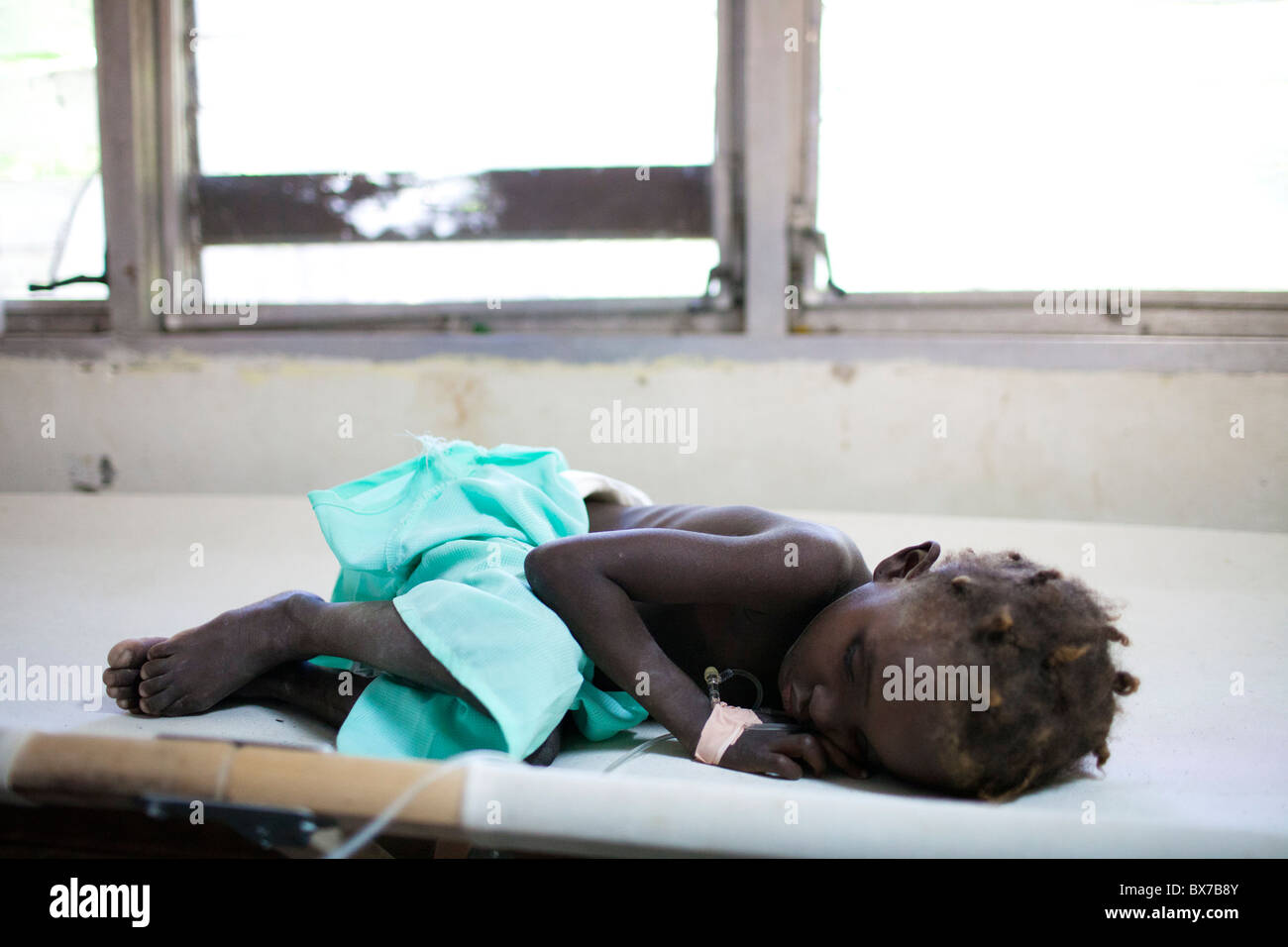 A young cholera patient sleeps on a cot at the Hospital Albert Schweitzer on Thursday, October