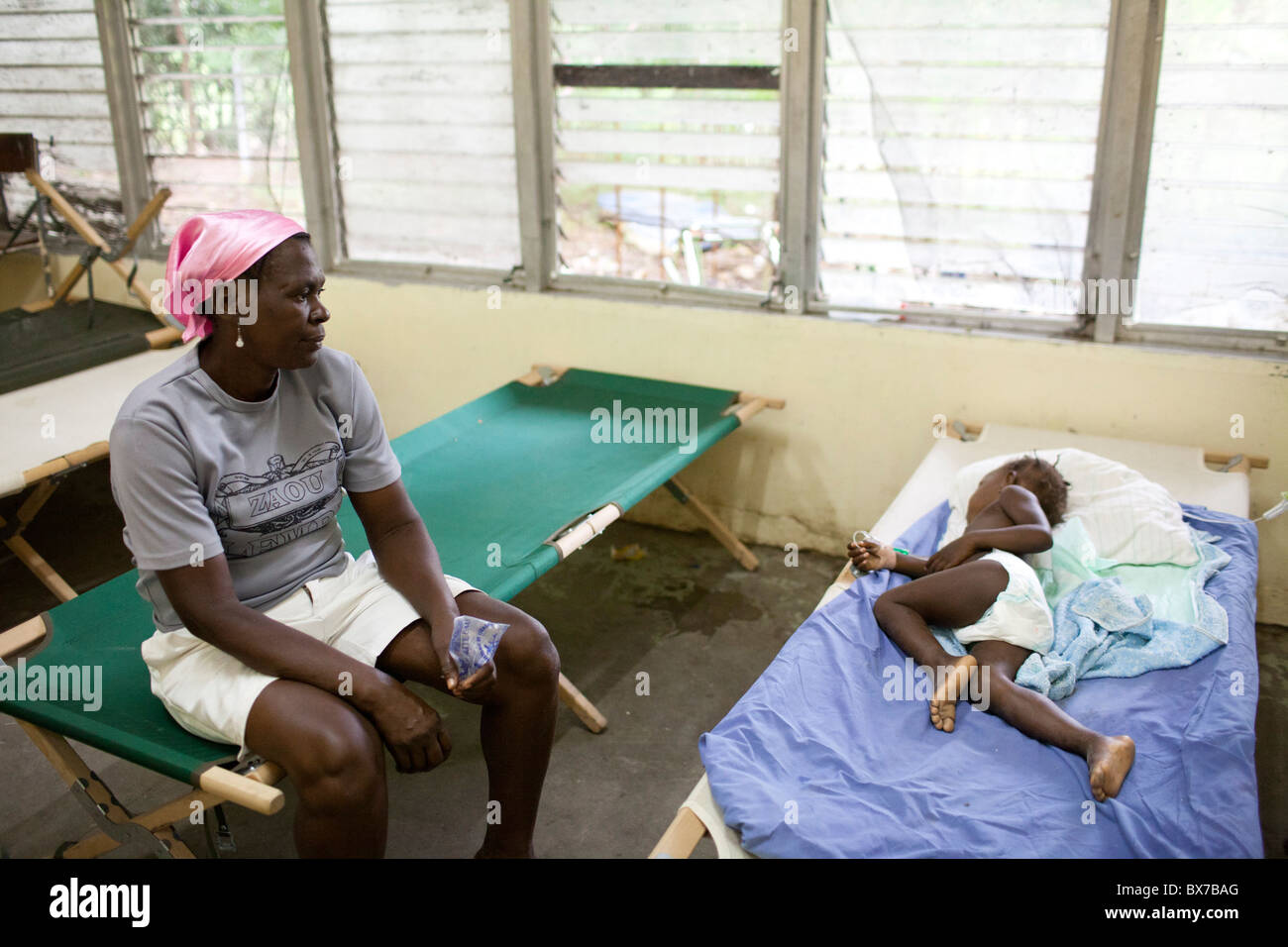 A woman watches over her young daughter, who is sick with cholera, at the Hospital Albert Schweitzer Stock Photo
